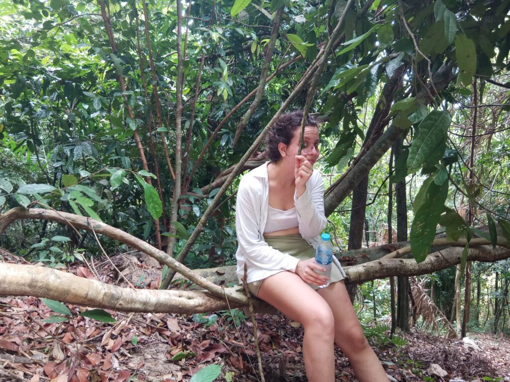 Zoe sitting on a tree the beyond tourist, travel in thailand, rainforest
